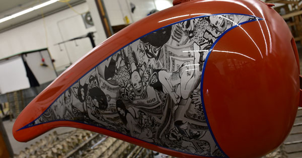 picture of a motorcycle gas tank after being hydro dipped with a black and white women graphic, splashed hydrographics motorcycle tank after being water transfer printed on