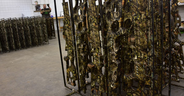 picture of a weapons rack with camouflage weapons on it after being hydro dipped, water transfer printing on weapons, splashed hydrographics water transfer printing on a rack of weapons