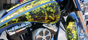 picture of a hydro dipped motorcycle that has a yellow skull and women design water transfer printed on it 