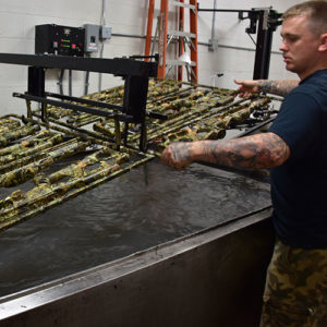 hydro dipping weapons into water to transfer a camouflage design onto them, hydro dipping, water transfer printing machine with weapons being dipped